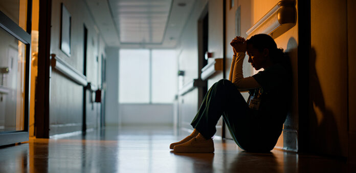 Doctor, stress and woman with depression, burnout and tired in hospital for medical news. Nurse, anxiety and female person with mental health, headache and sad sitting on floor for patient death
